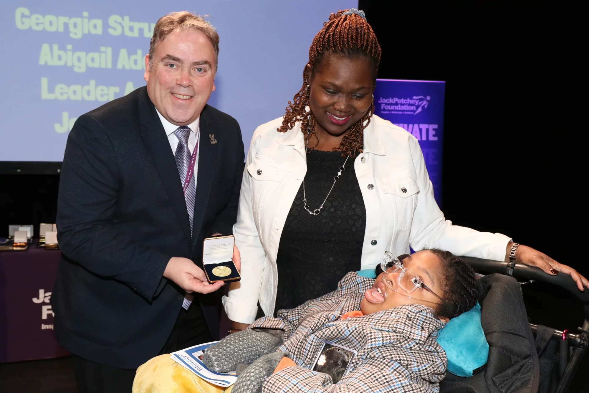Abigail with two adults at a Jack Petchey Foundation award presentation.