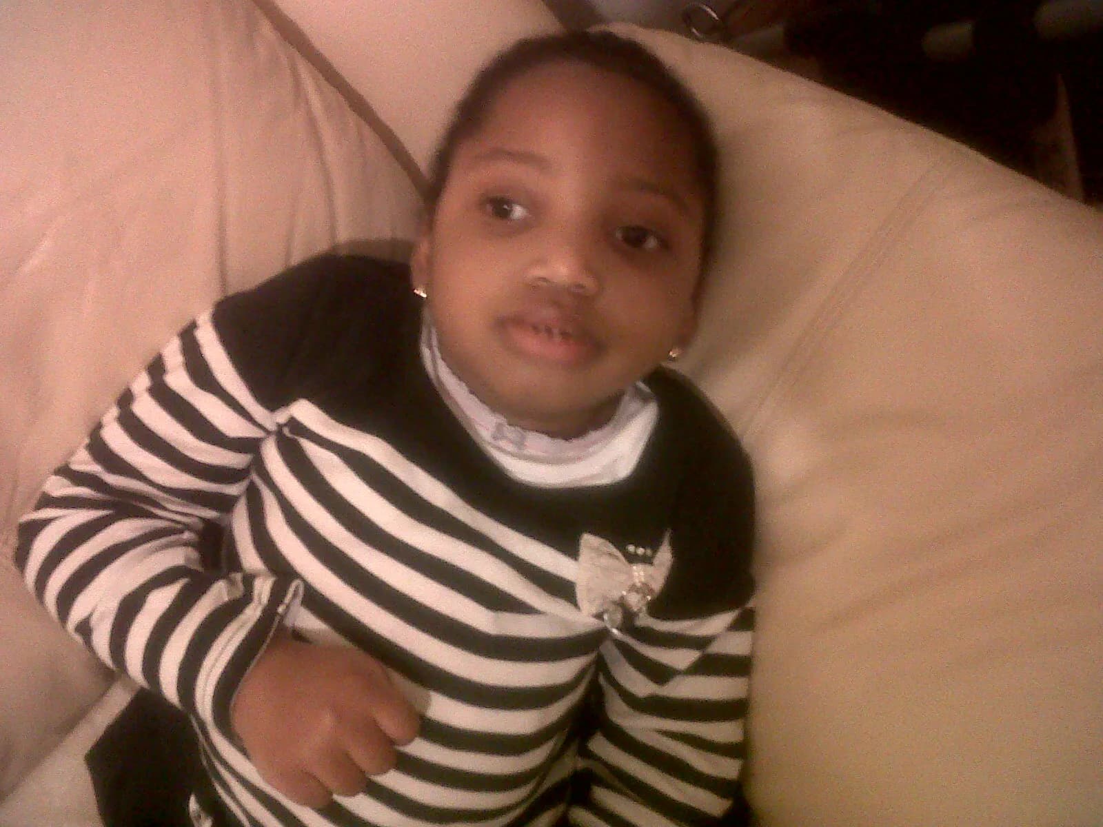 Young Abigail wearing a striped top and looking toward the camera.