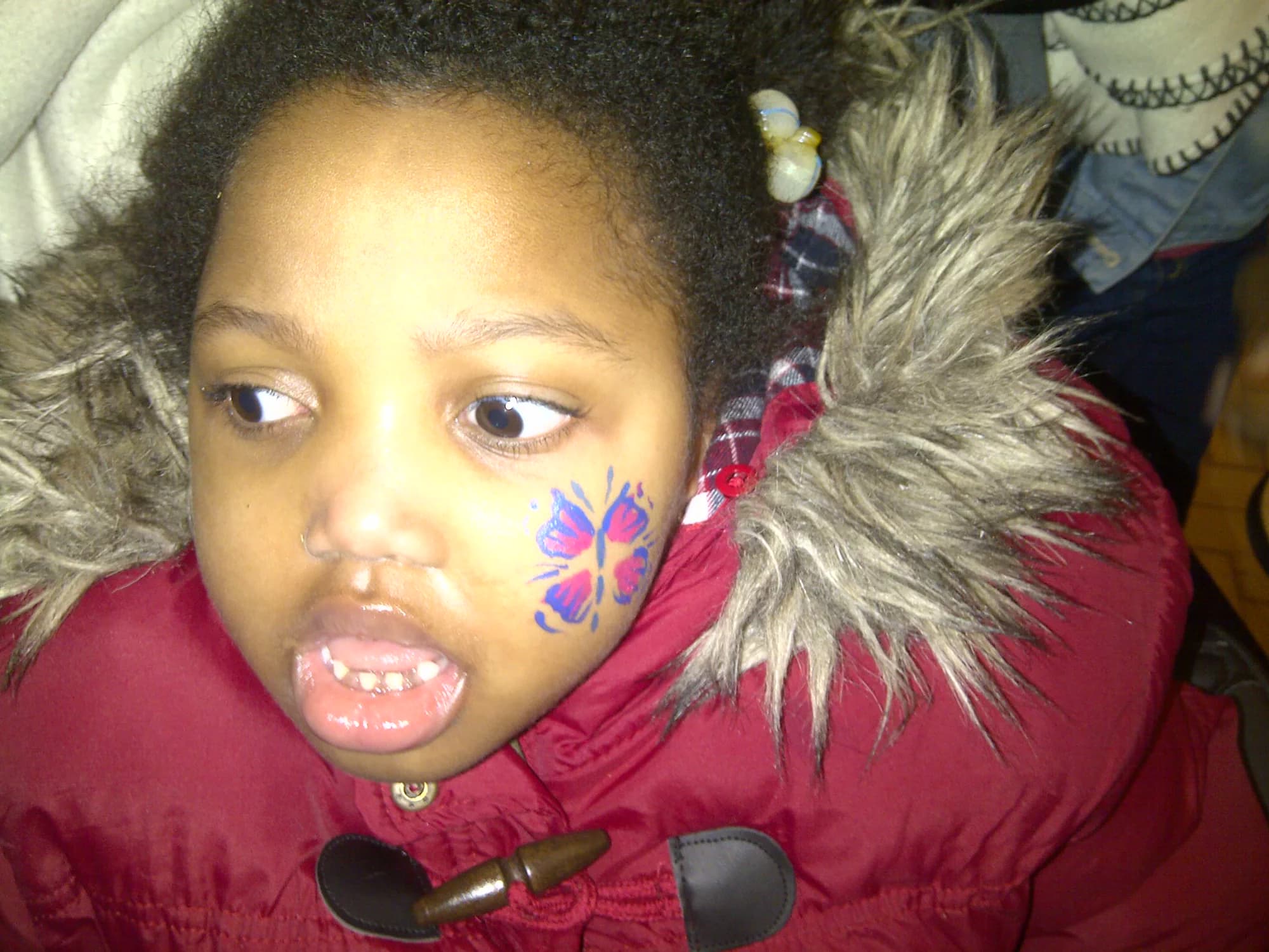Abigail with colourful face paint on her cheek.