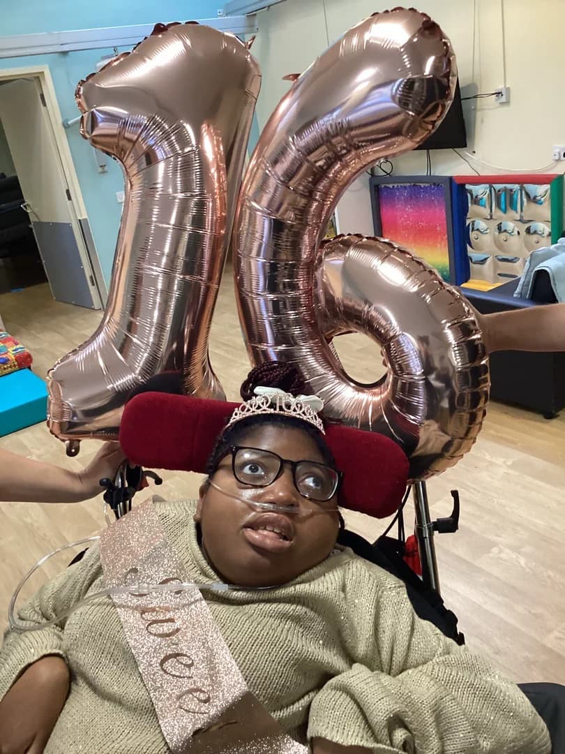 Abigail celebrating her sixteenth birthday with silver balloons.