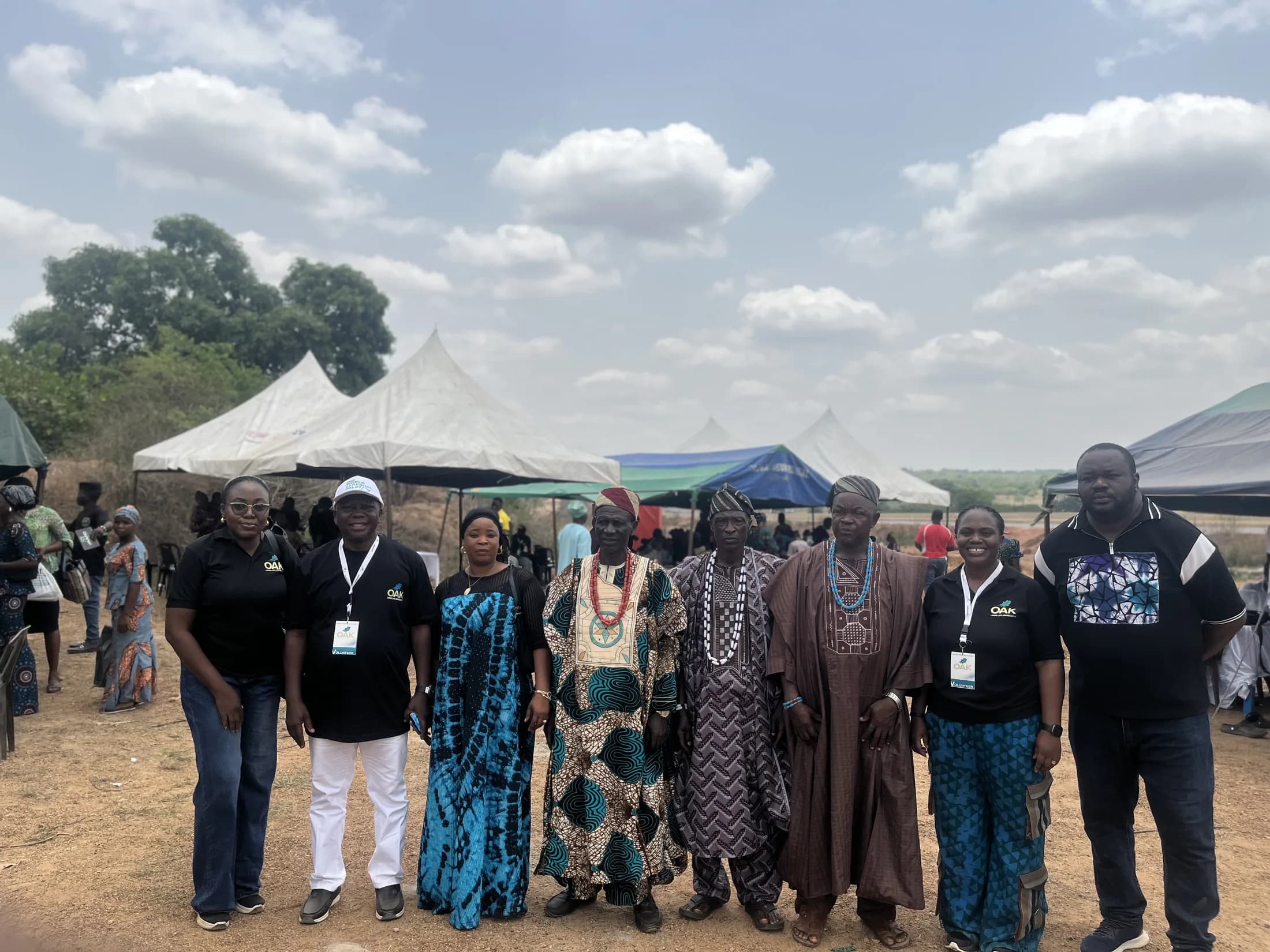 OAKonsult representatives and community leaders standing at the outreach site
