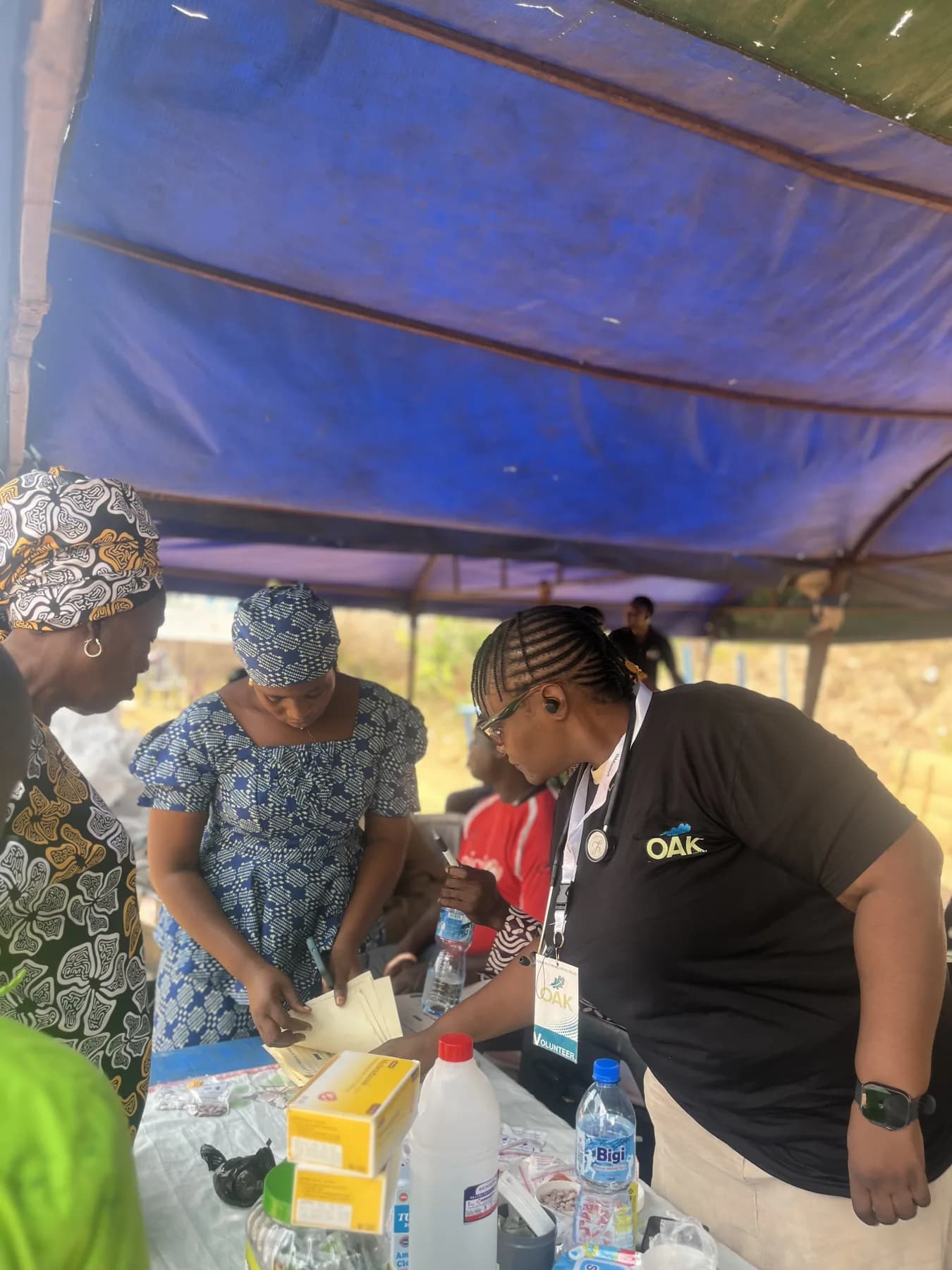 Volunteers organising supplies at an outdoor medical outreach station