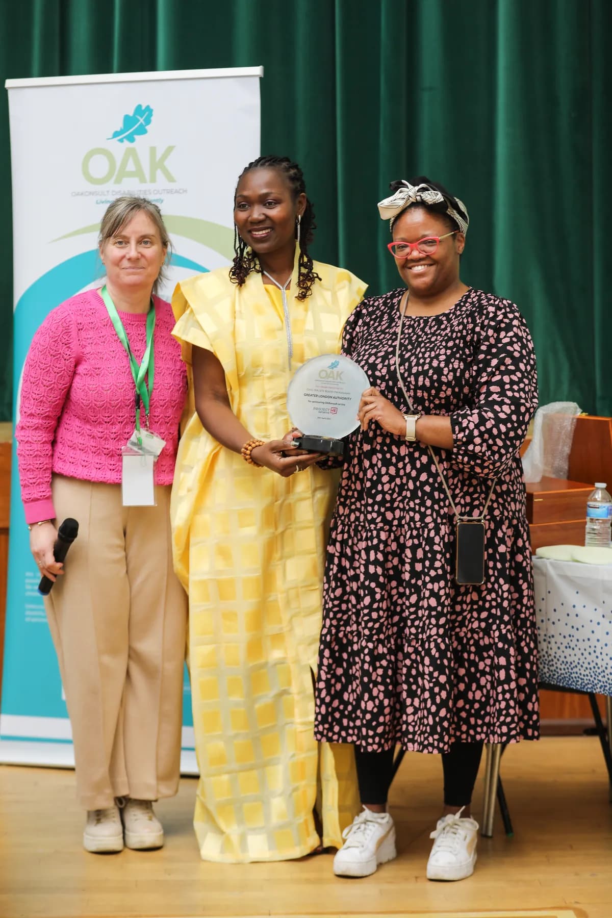 Three women smiling during an OAKonsult recognition presentation
