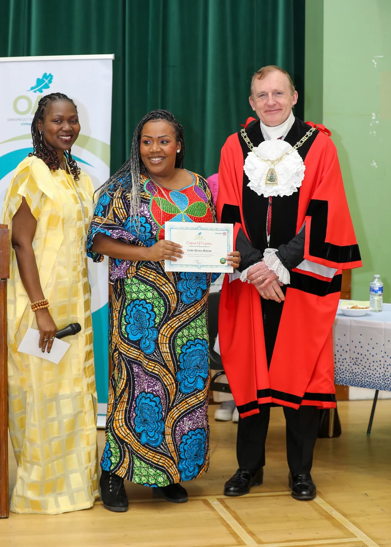 A Project ME participant holding her certificate with event hosts