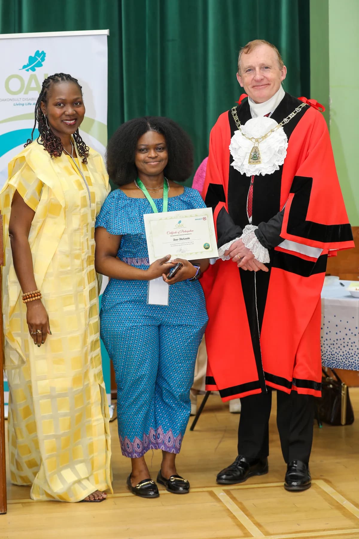 A Project ME participant holding a certificate on stage