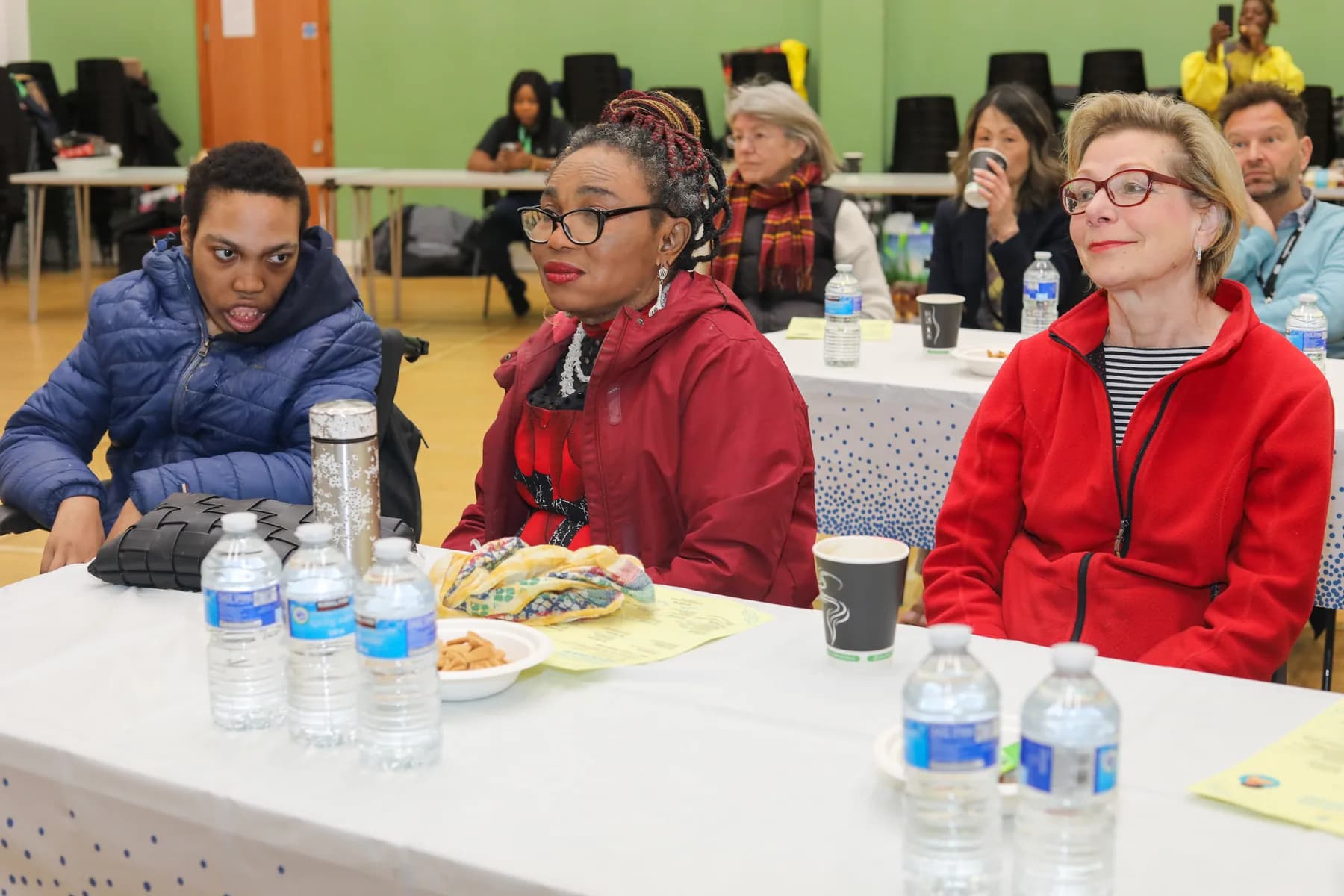 Project ME guests listening from a table during the event